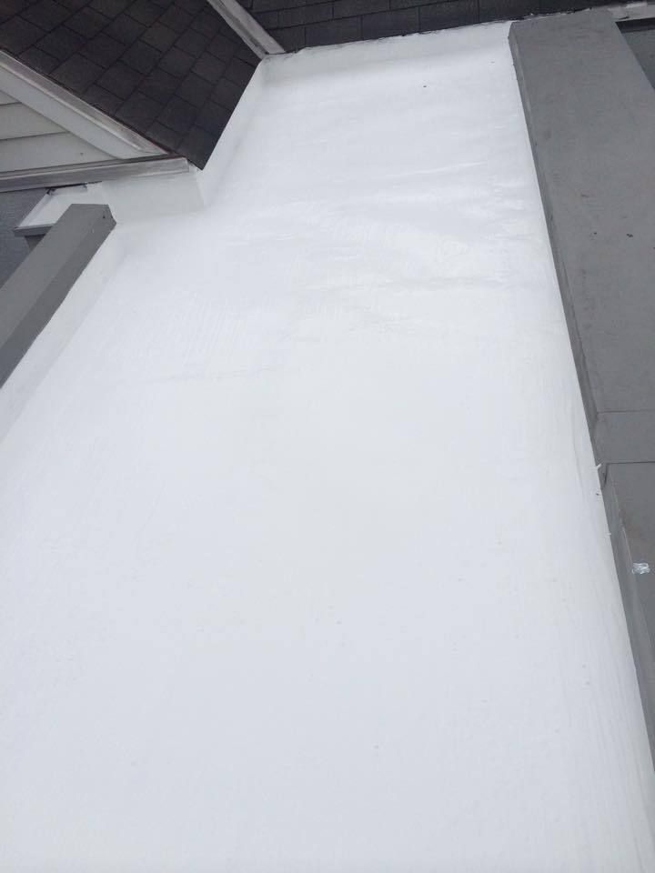 White coated flat roof with a dark roof section visible.
