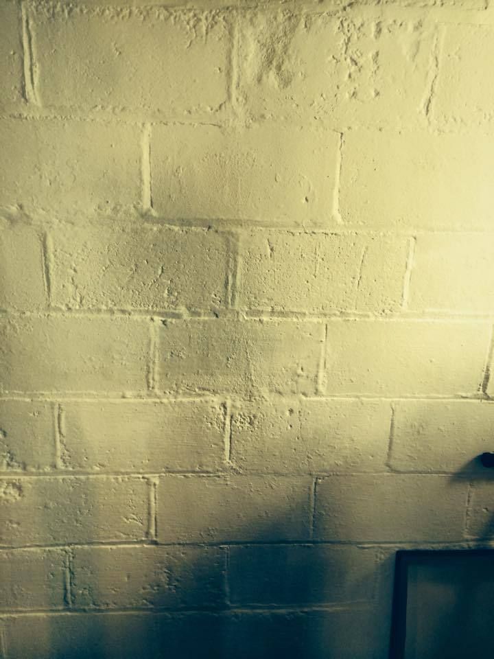 White painted brick wall with a shadow in the lower right corner.