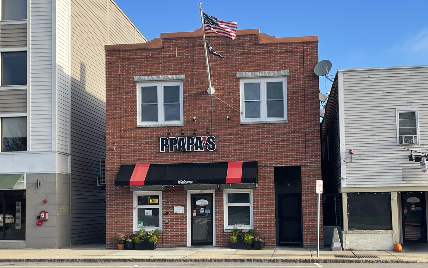 PPapa's Pizza Bar brick building with awning and American flag.