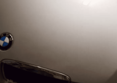 Silver BMW car trunk with emblem and handle.