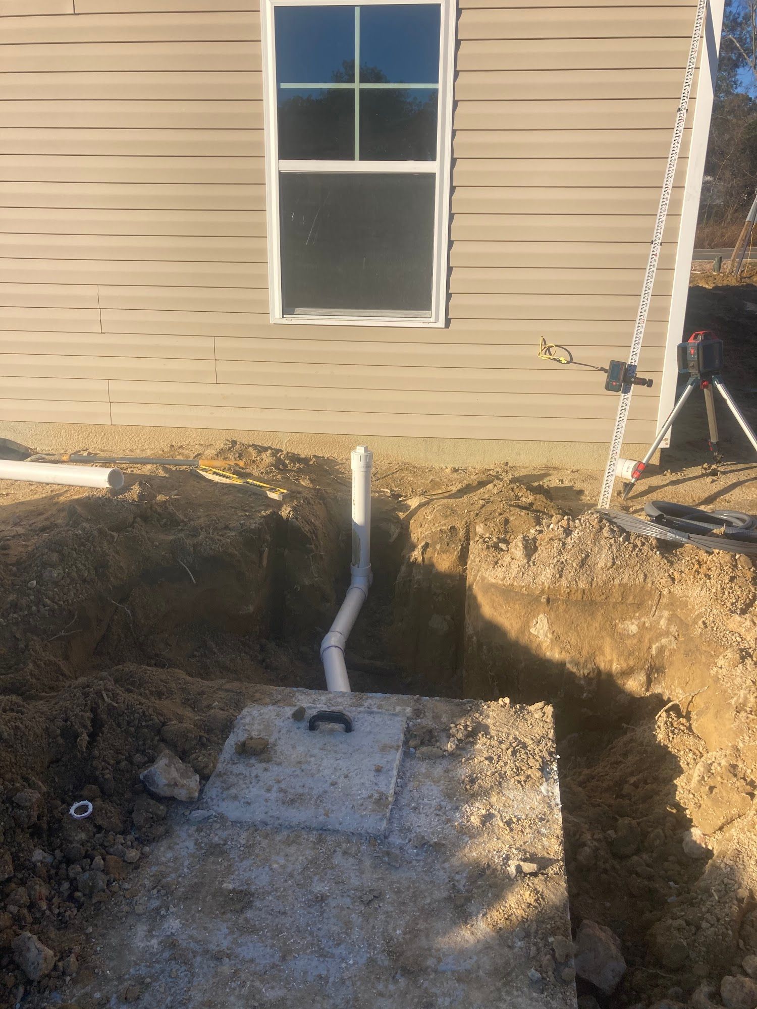 A septic tank is being installed in the backyard of a house.