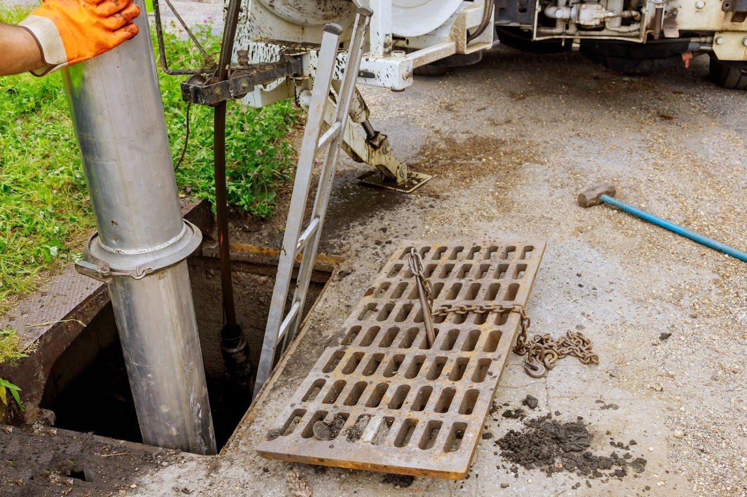 A man is cleaning a drain with a vacuum truck.