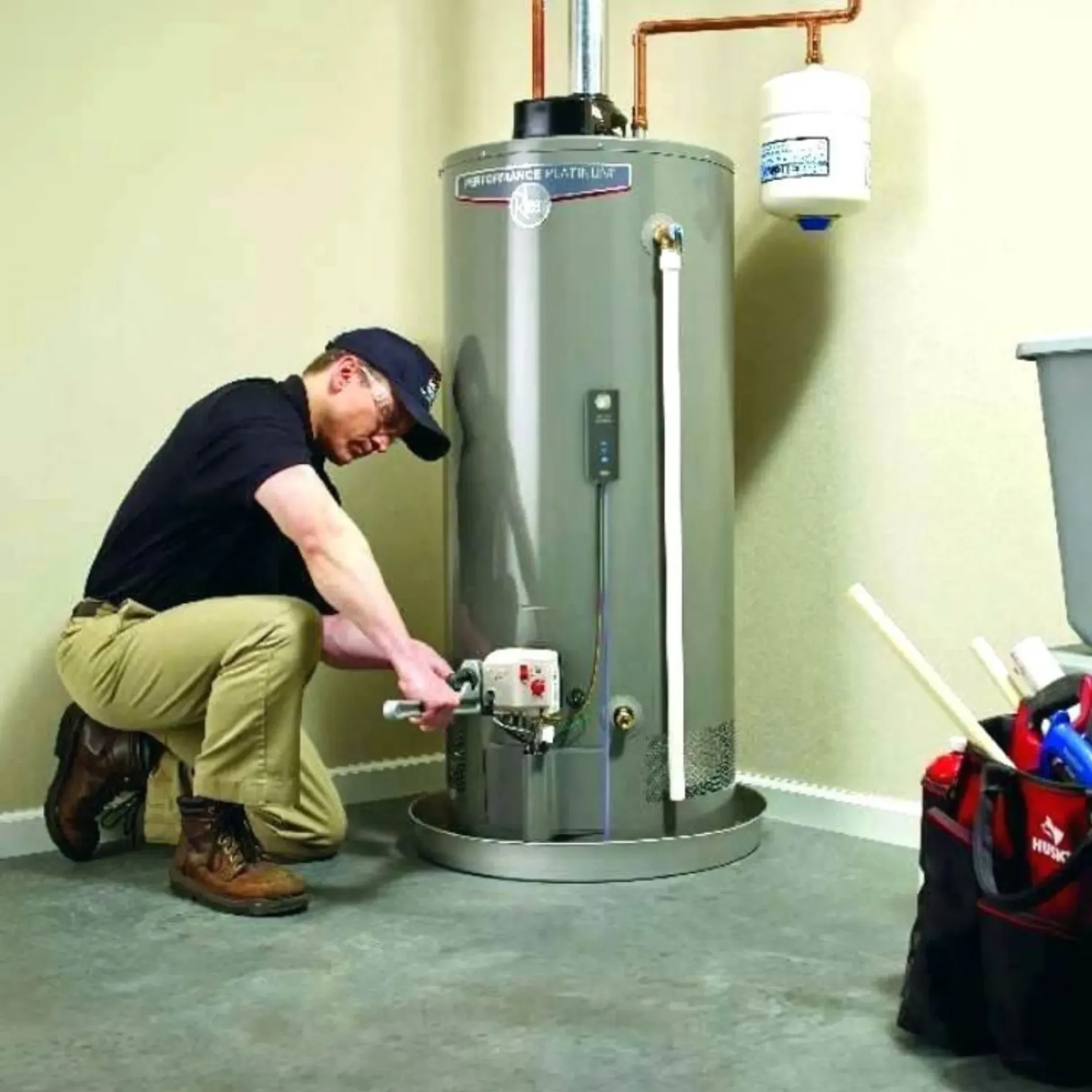 ReplacementZone Plumbing  - A man is working on a water heater in a basement