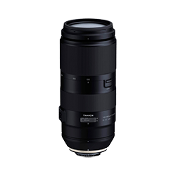 a black camera lens is sitting on a white surface .