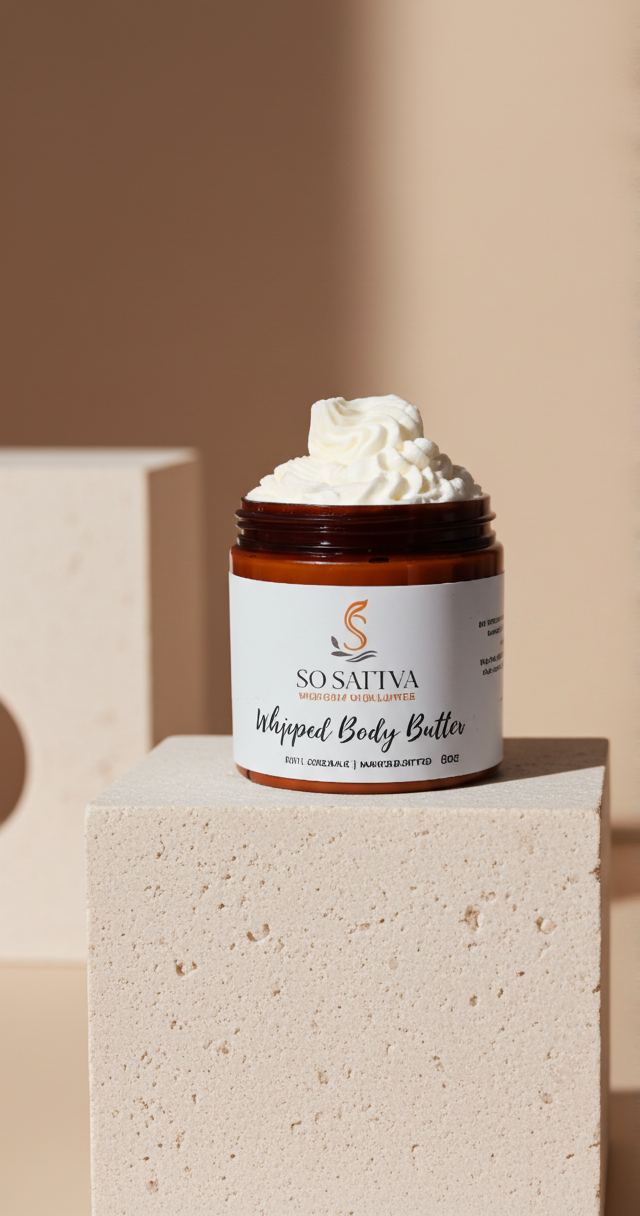 Three amber jars of whipped body butter topped with cream, surrounded by rose petals in a sunlit bathroom setting.