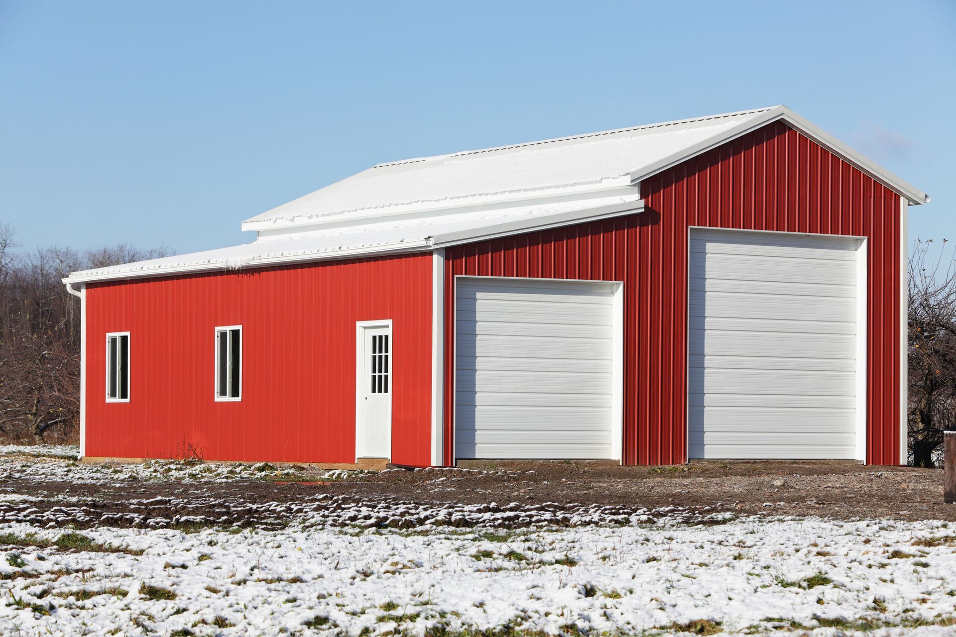 A white house with a black gutter and a blue sky in the background.