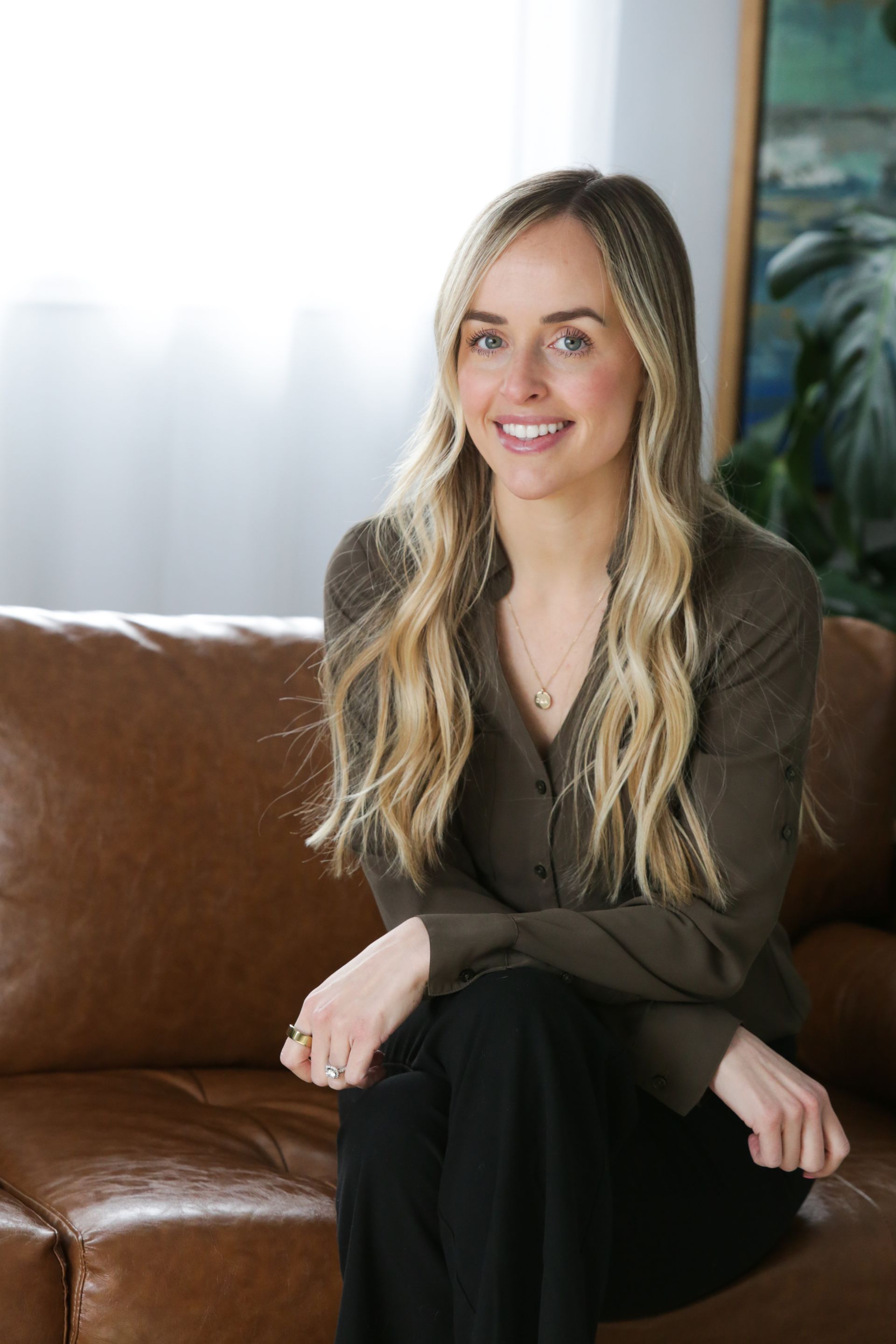 A woman in a black jacket and purple shirt is smiling for the camera.
