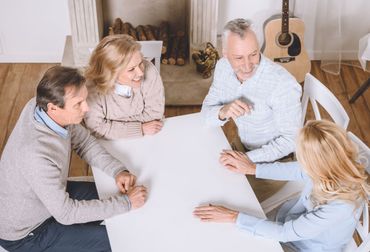 A group of people are sitting around a table playing a game.