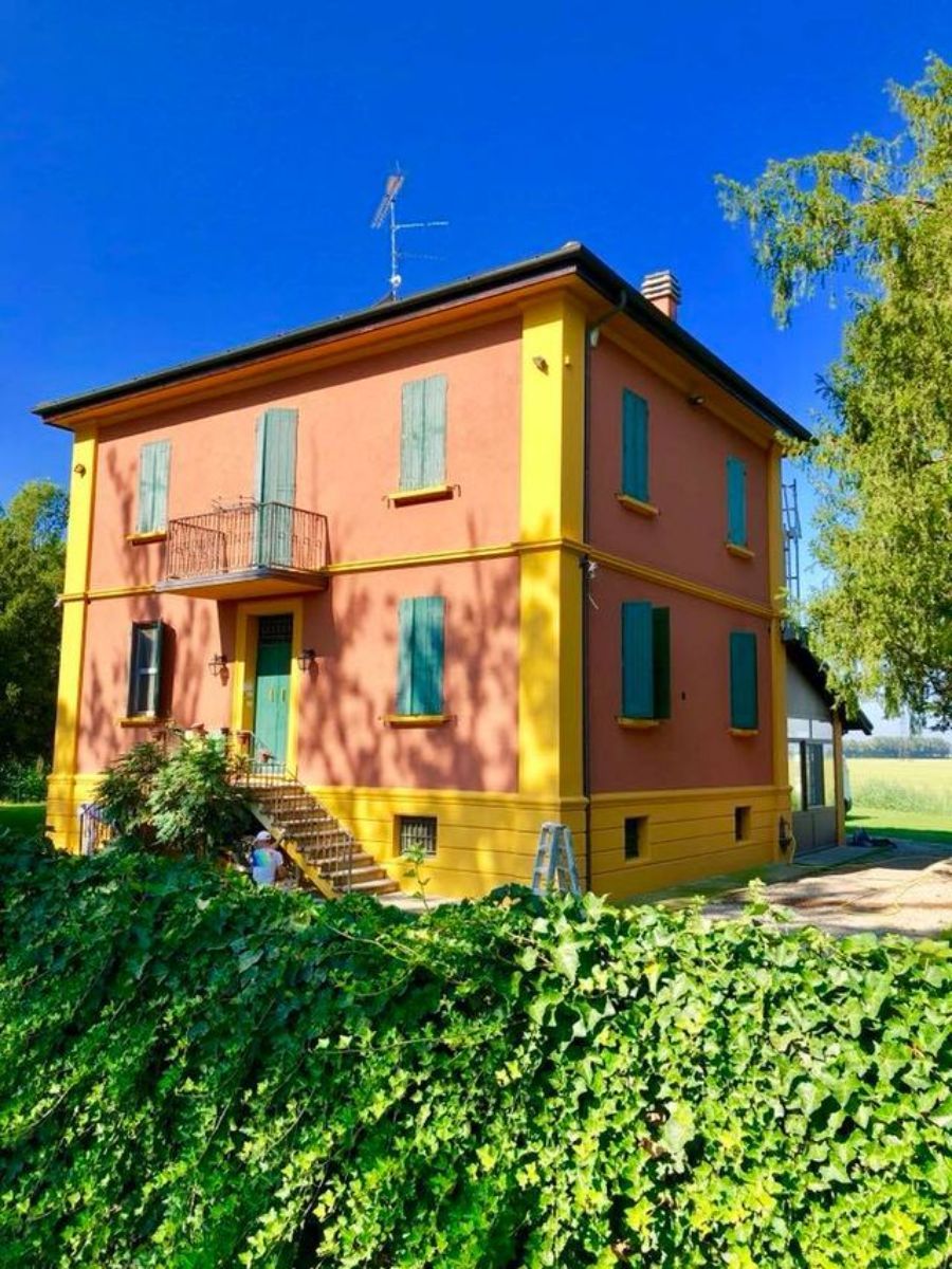 Casa con parete rosa salmone e giallo