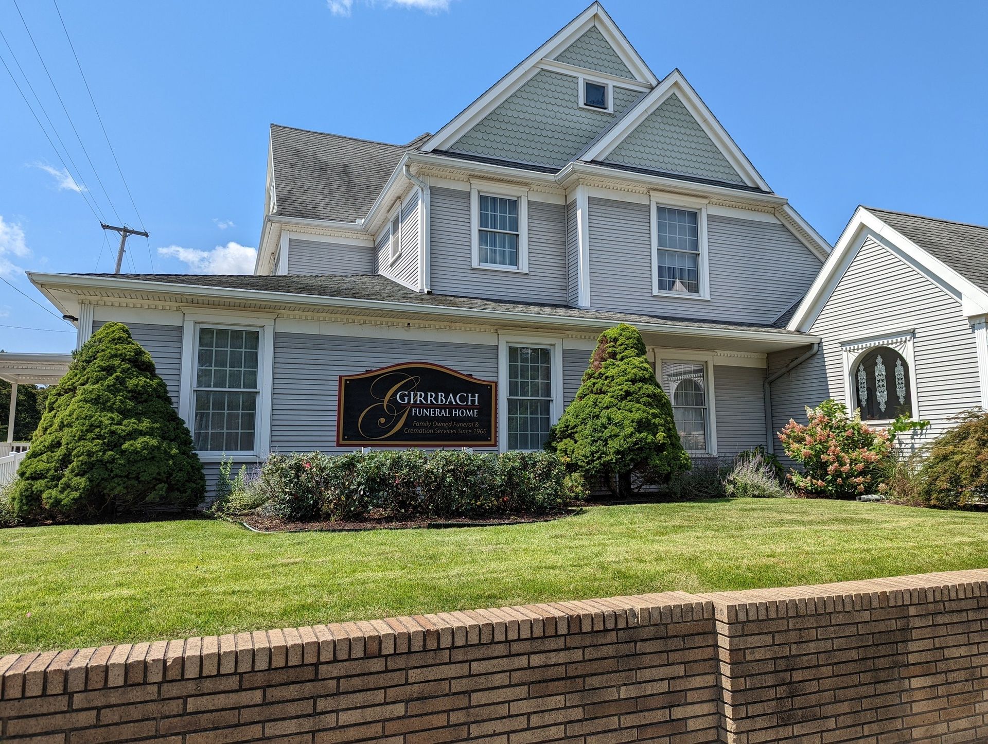 The front door of a house with a porch and plants in front of it.