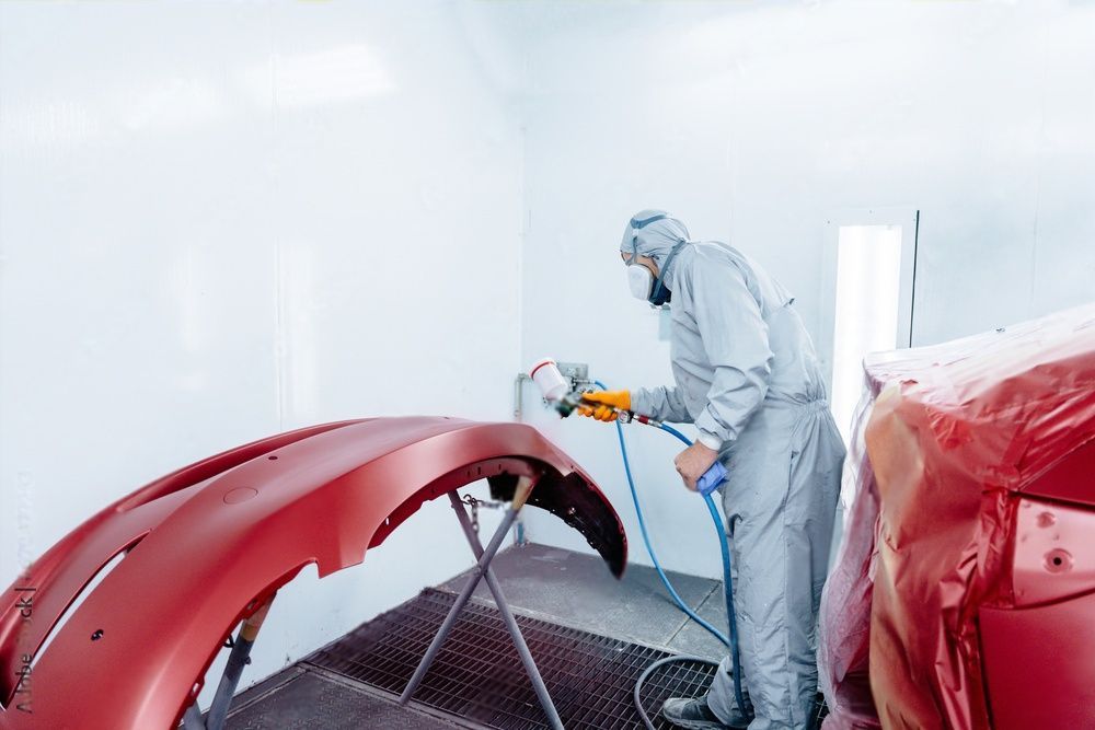 Een witte Volvo XC90 wordt gerepareerd in een garage.