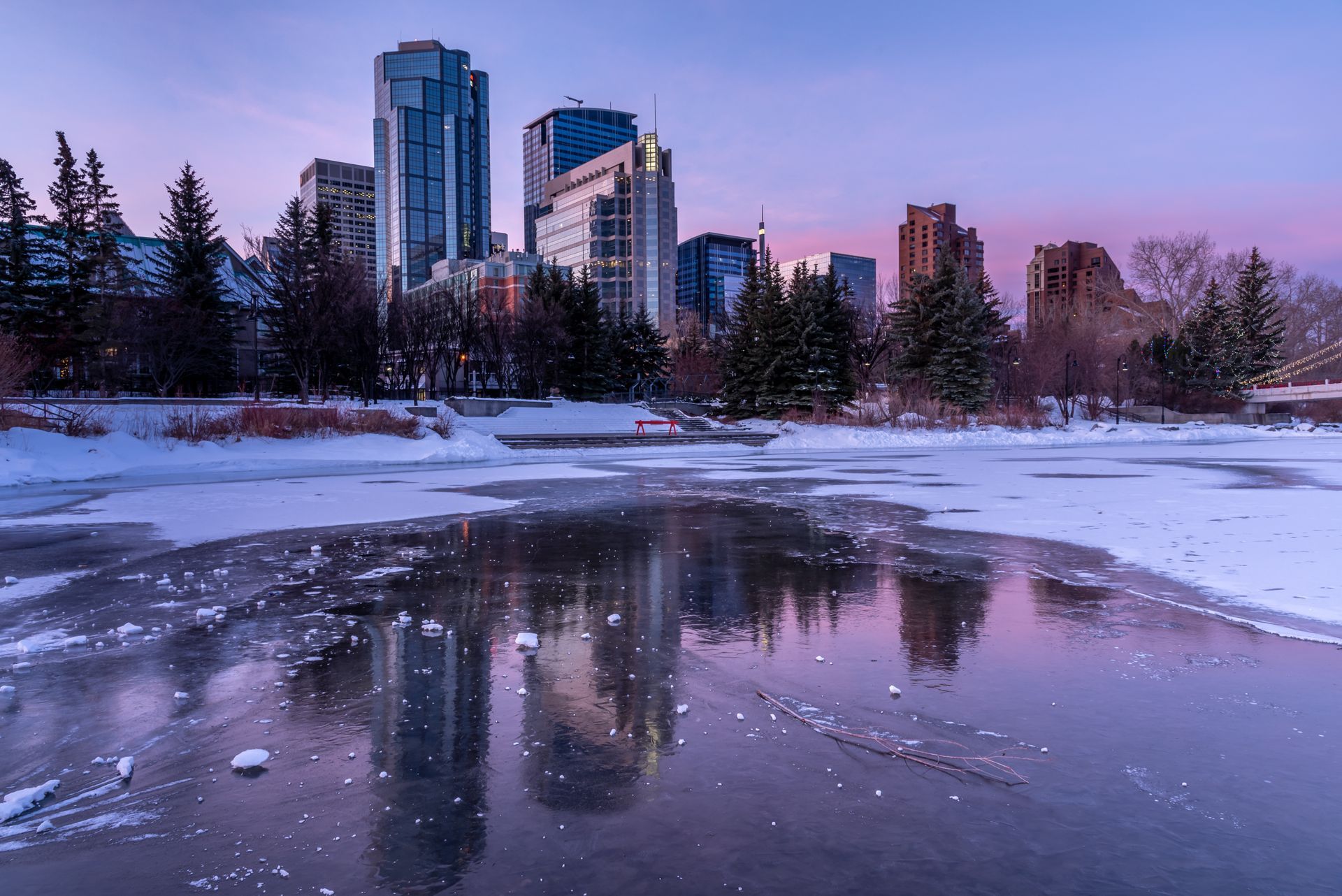 Panorama urbain se reflétant dans une rivière en plein dégel printanier au coucher du soleil.