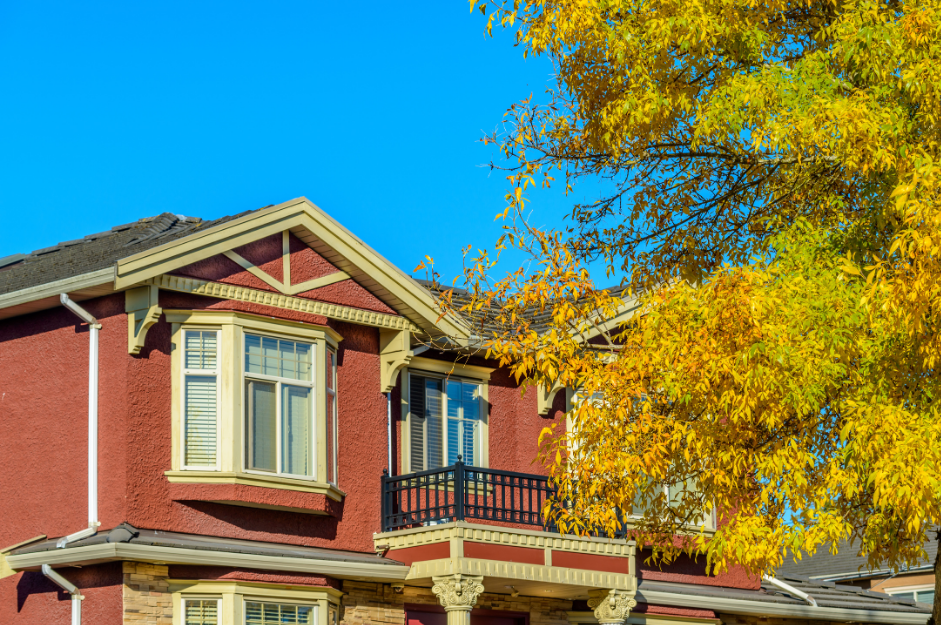 Maison bien entretenue en été avec arbres et ciel dégagé, illustrant l’entretien saisonnier