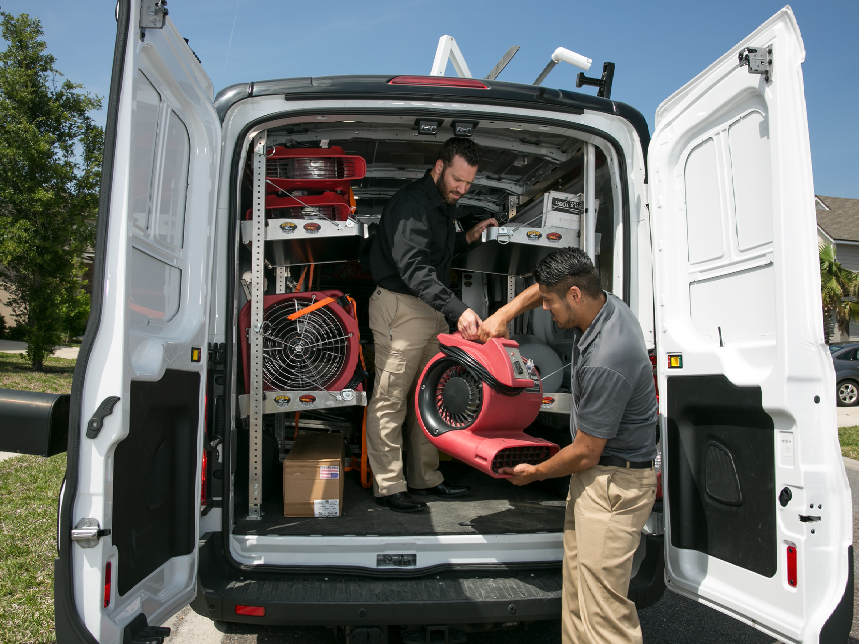 Two Paul Davis Restoration Experts Unpacking Air Movers to Handle Water Damage