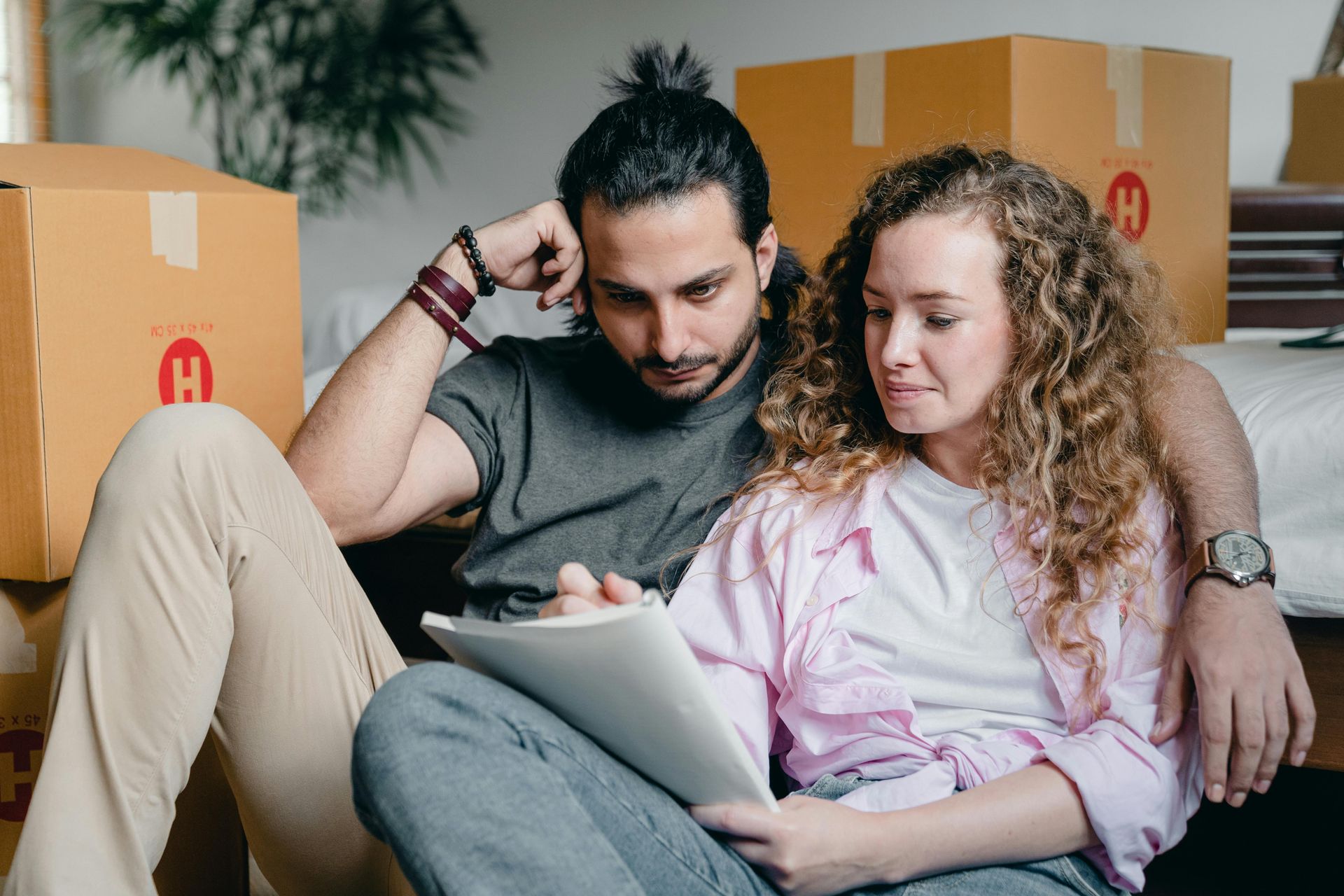 A couple sits on the couch, both reading an estate planning document