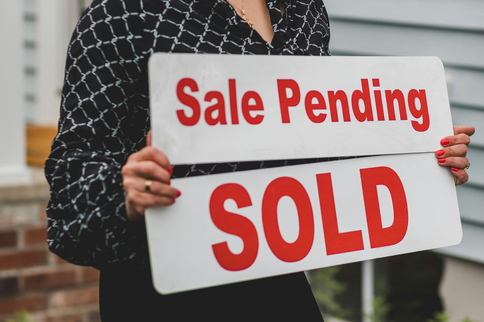 A real estate agents holds up both a 