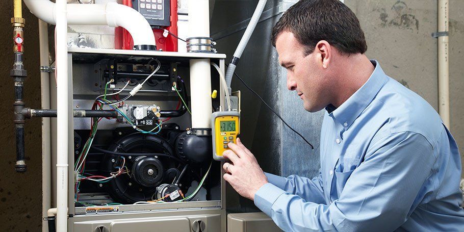 A man in a blue shirt is working on a heating system.