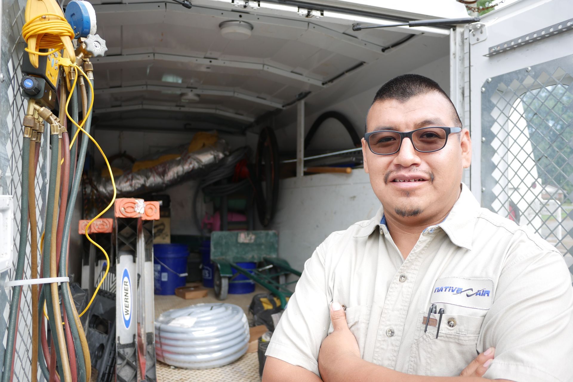 A man wearing sunglasses is standing in front of a white van