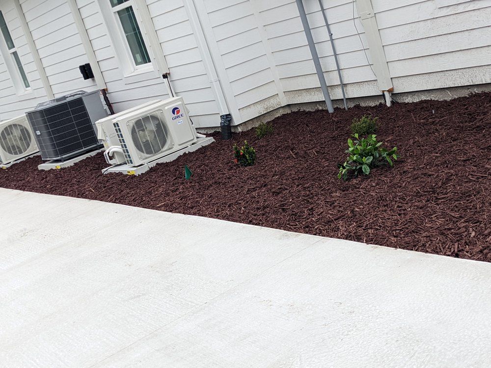 A row of air conditioners are sitting on the side of a house.