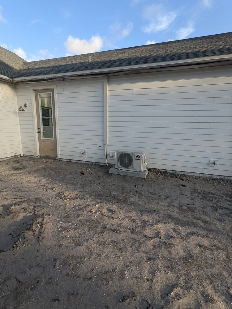 A white house with a small air conditioner on the side of it.