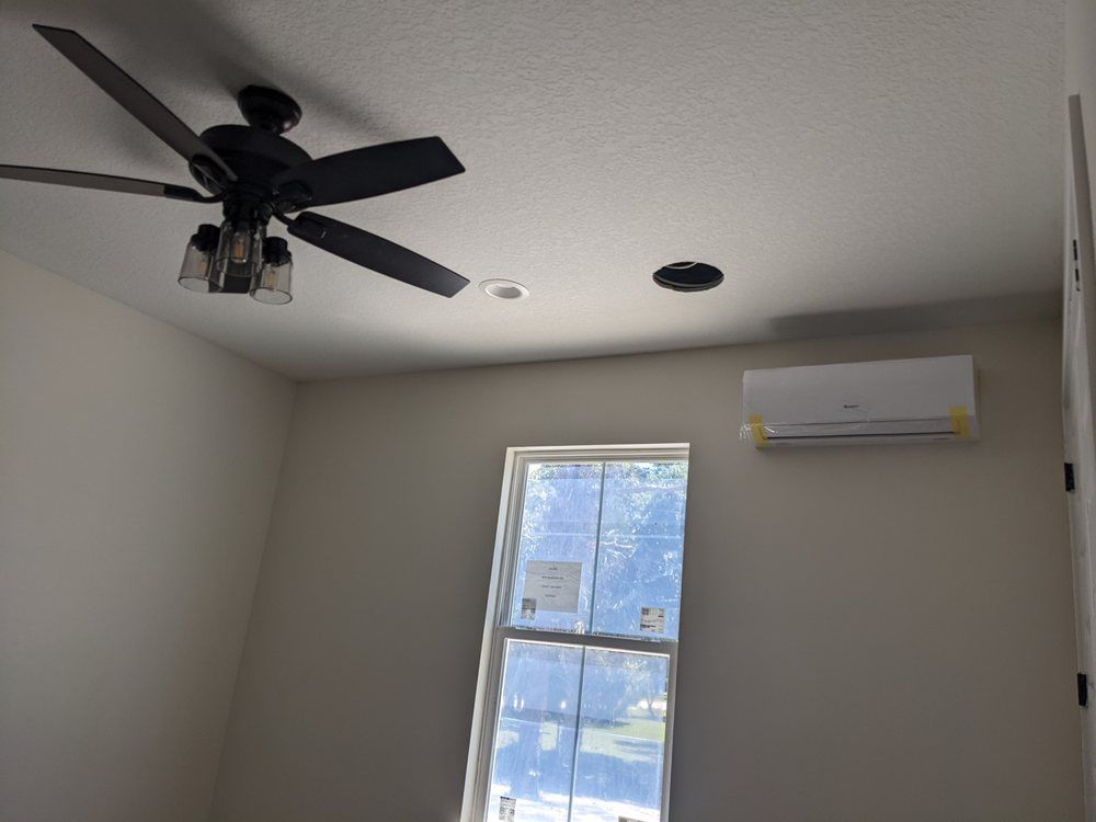 A room with a ceiling fan and a window