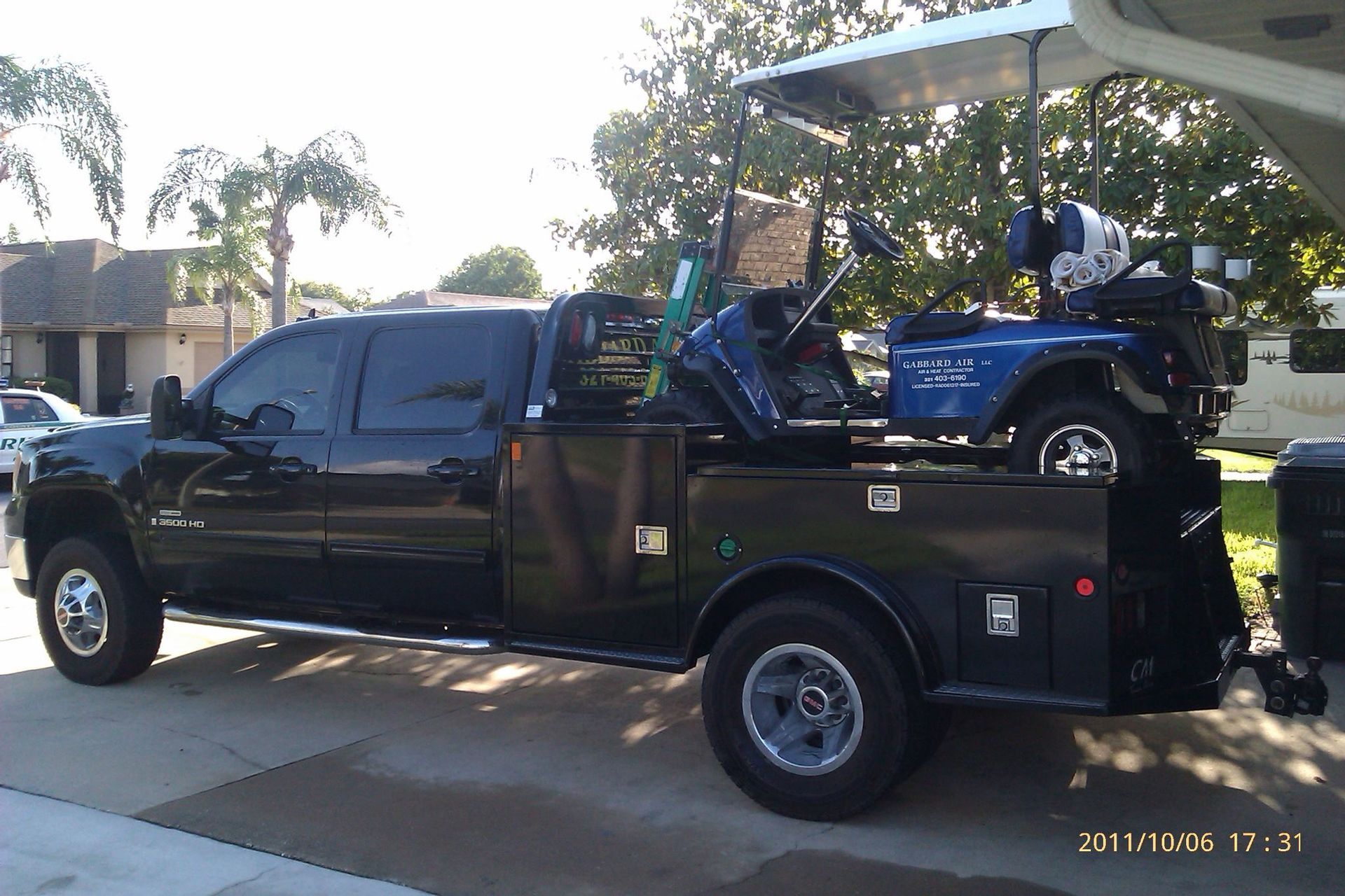 A black truck with a golf cart in the bed