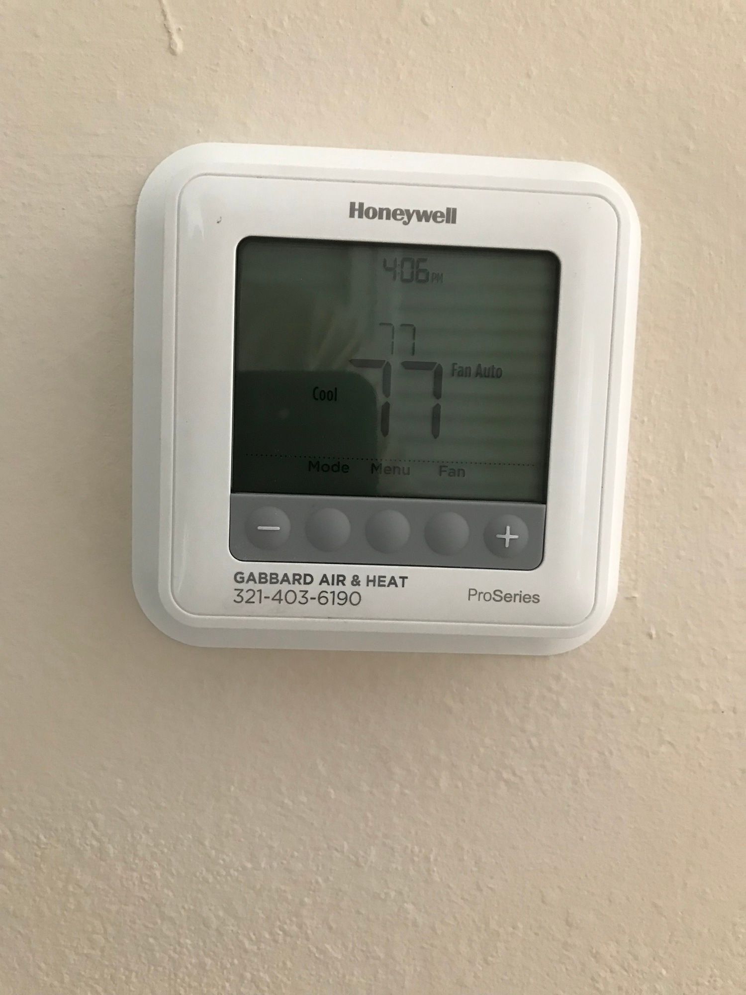 A honeywell thermostat is mounted on a wall.