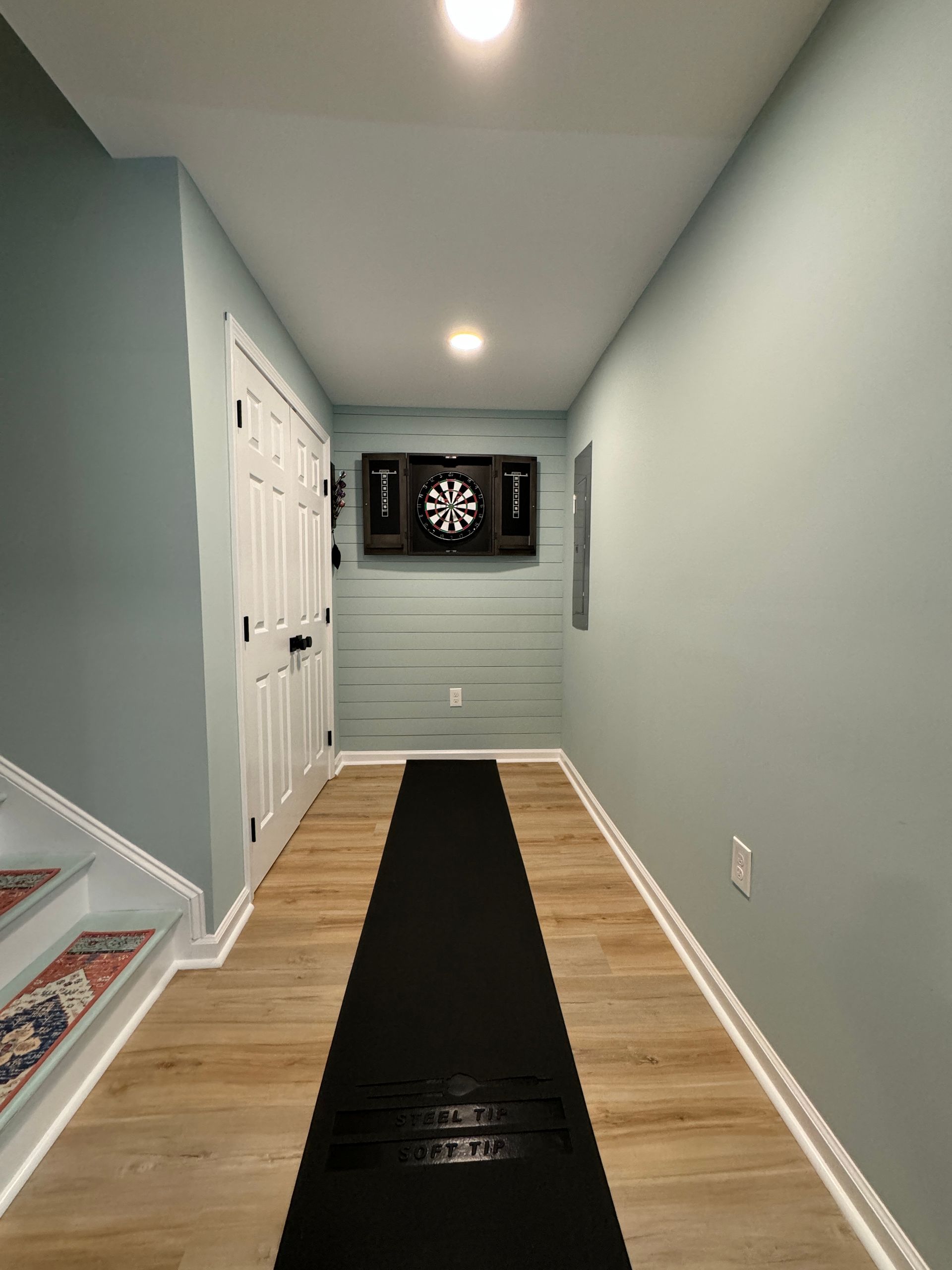 A hallway with a dart board on the wall