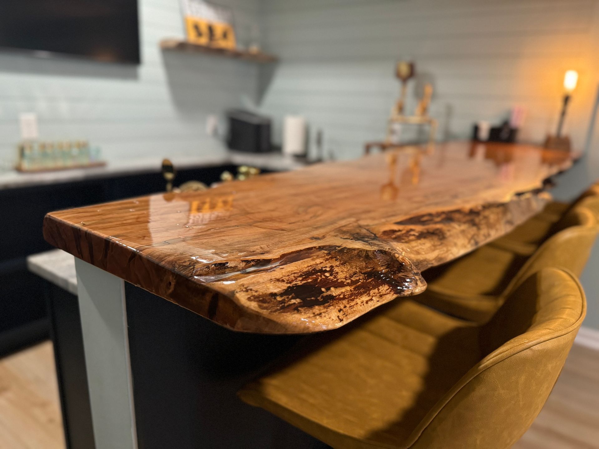 A kitchen with a wooden counter top and yellow chairs.