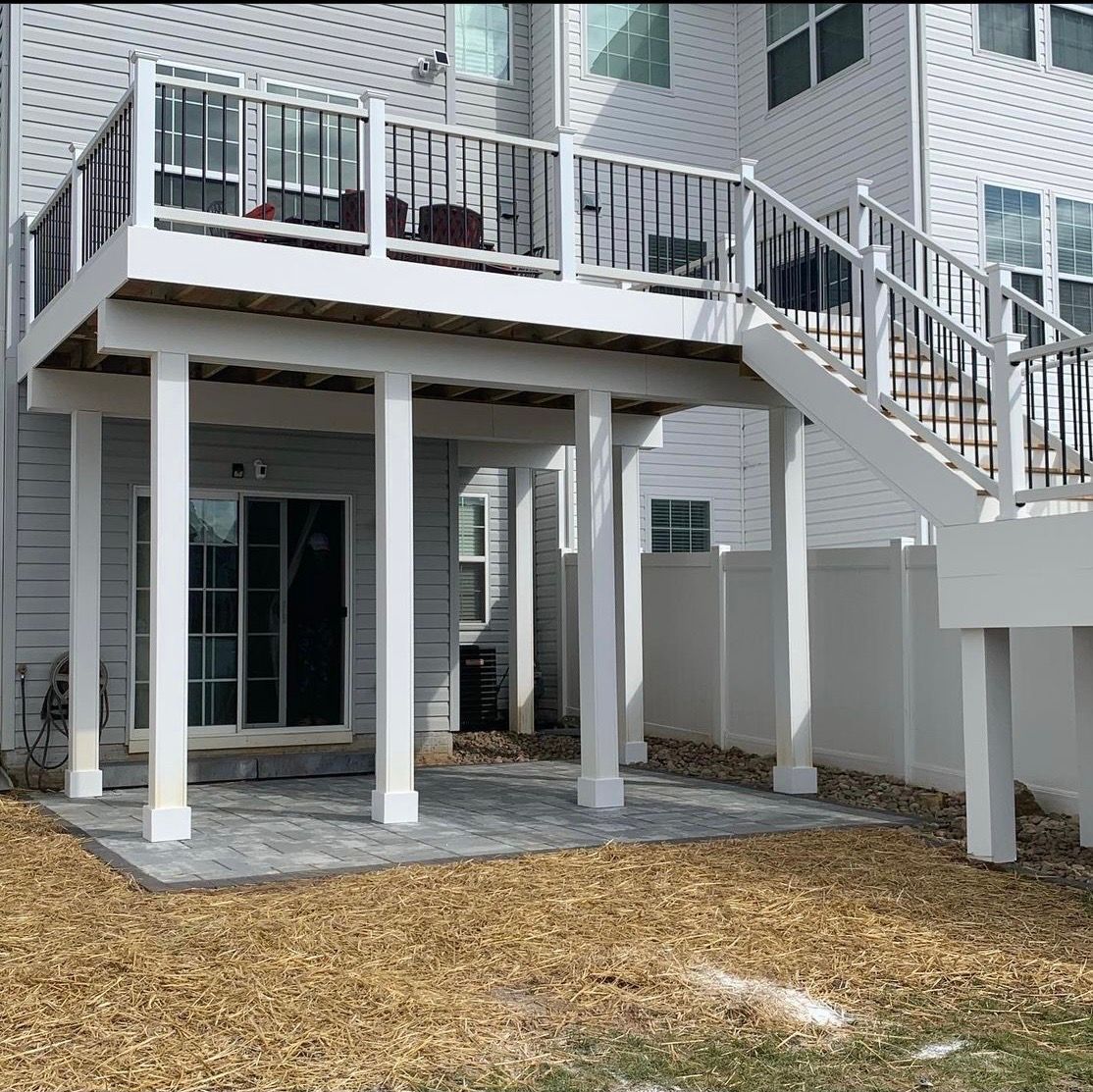 A white house with a white deck and stairs
