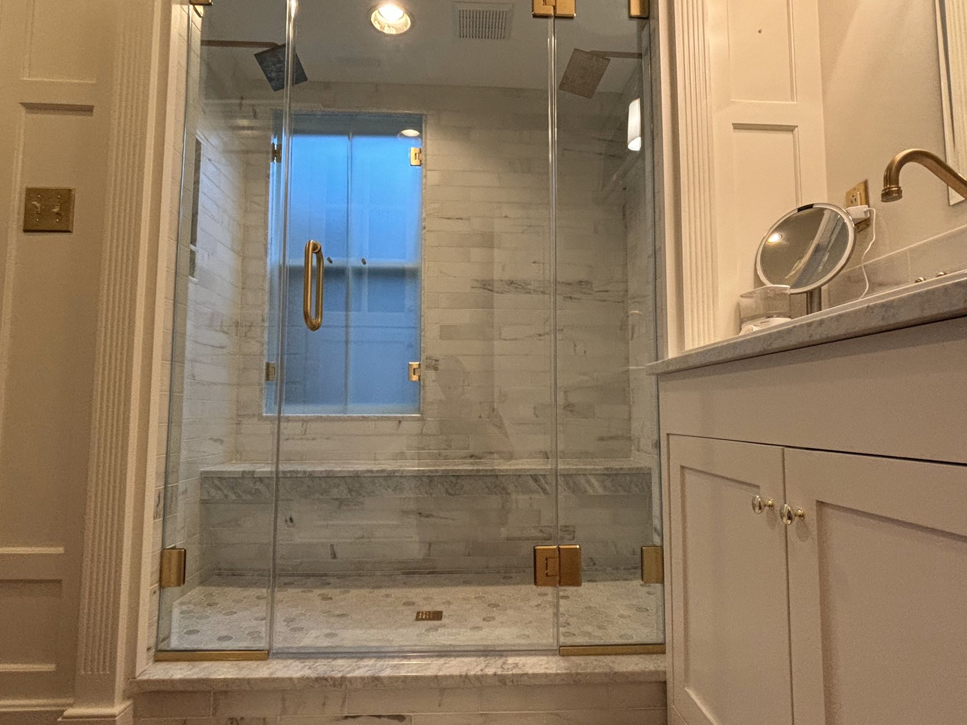 A bathroom with a toilet , sink , shower and mirror.