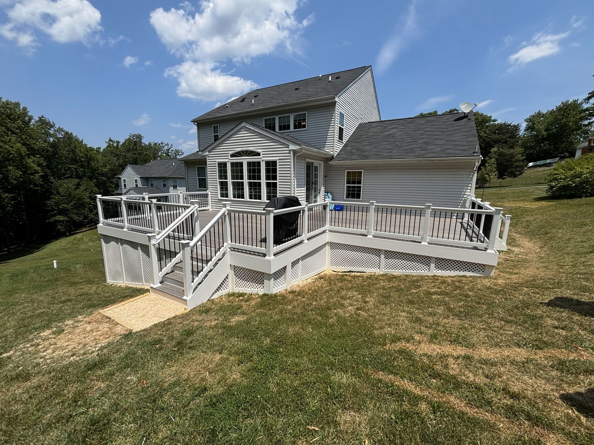 A large white house with a large deck in front of it.