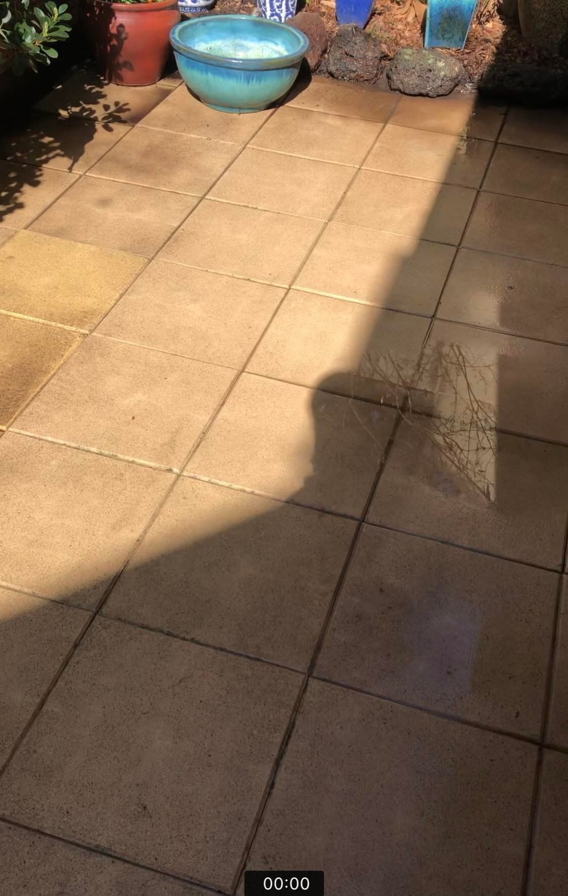 Pressure washing outdoor tiles to remove built-up dirt and stains