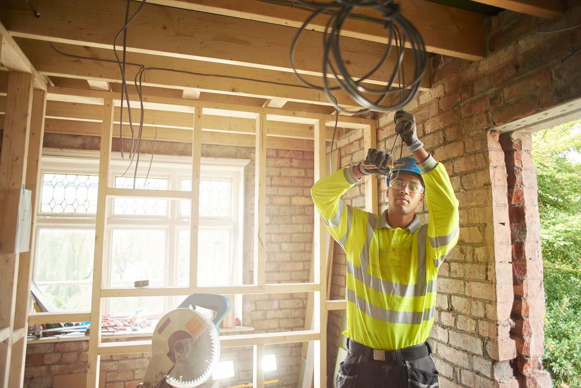 A man is standing in a room with a drill in his hand.