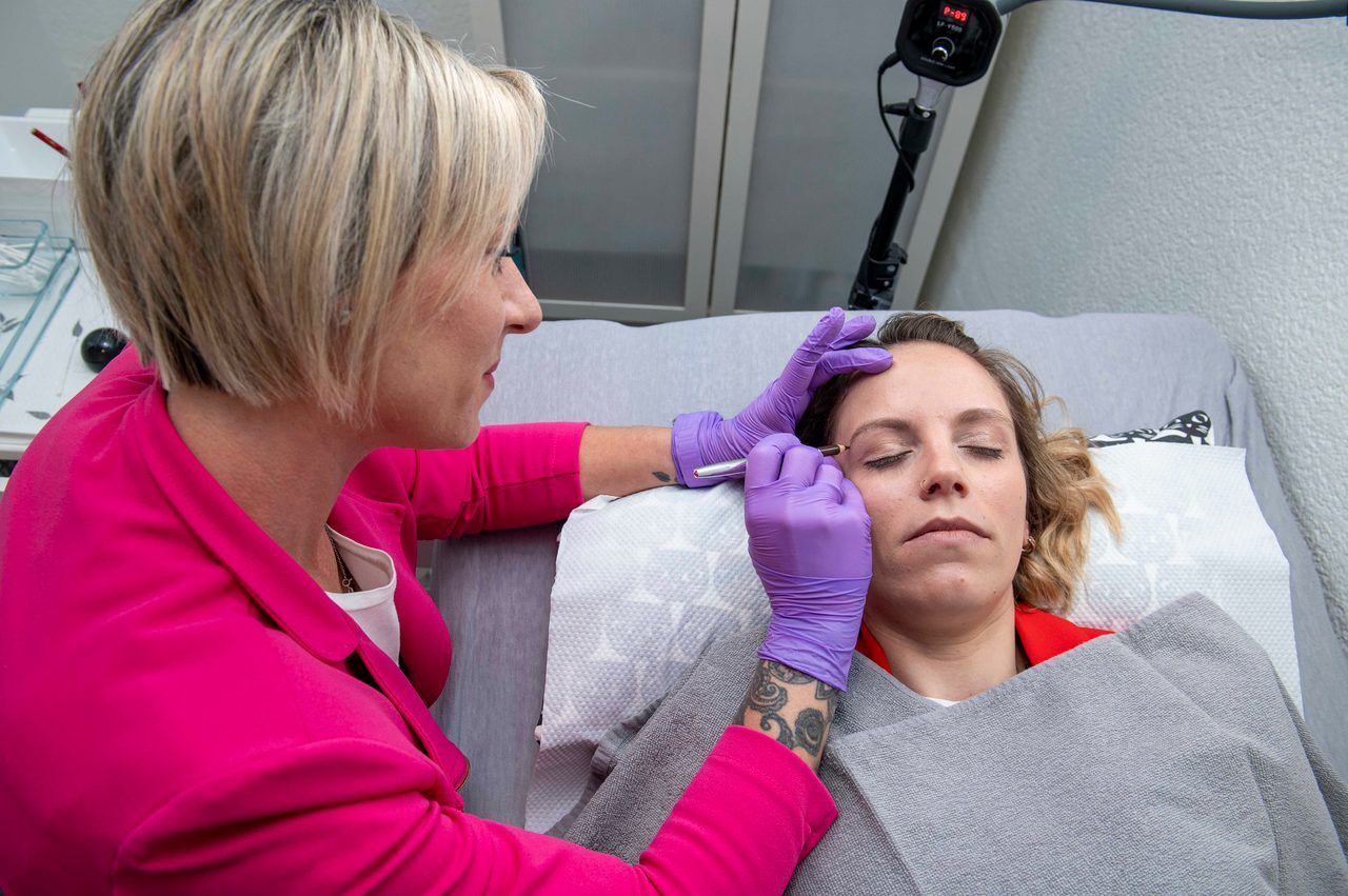 Frau erhält Permanent Make-Up Behandlung bei den Augenbrauen