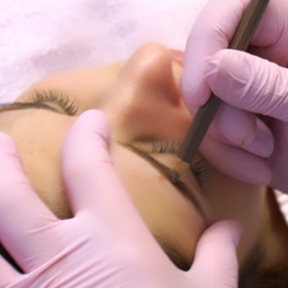Person erhält Permanent Make-Up Behandlung bei den Augenbrauen.