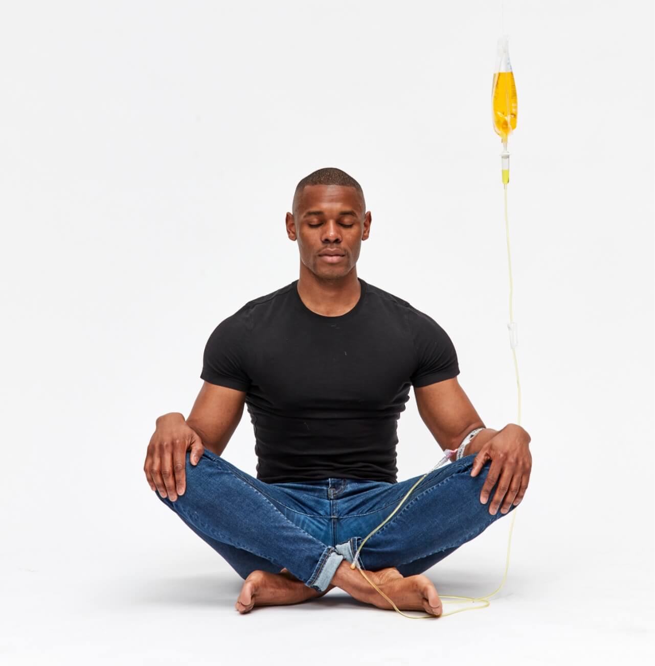 A man is sitting in a lotus position with his legs crossed.