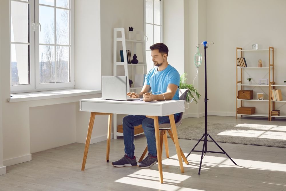 A man is sitting at a desk using a laptop computer.