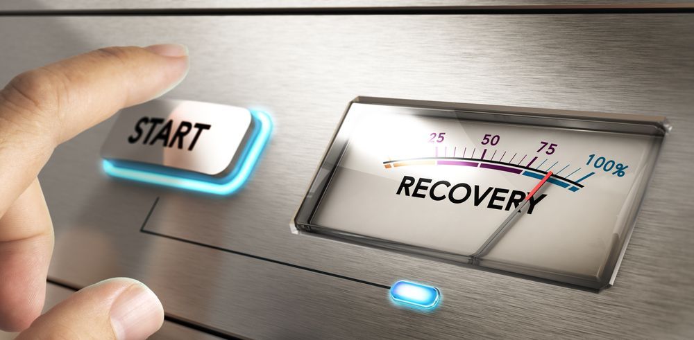 A person is pressing a start button next to a recovery button