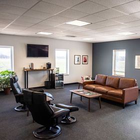 Waiting room with comfortable seating, TV, and coffee. | Don & Sons Body Shop