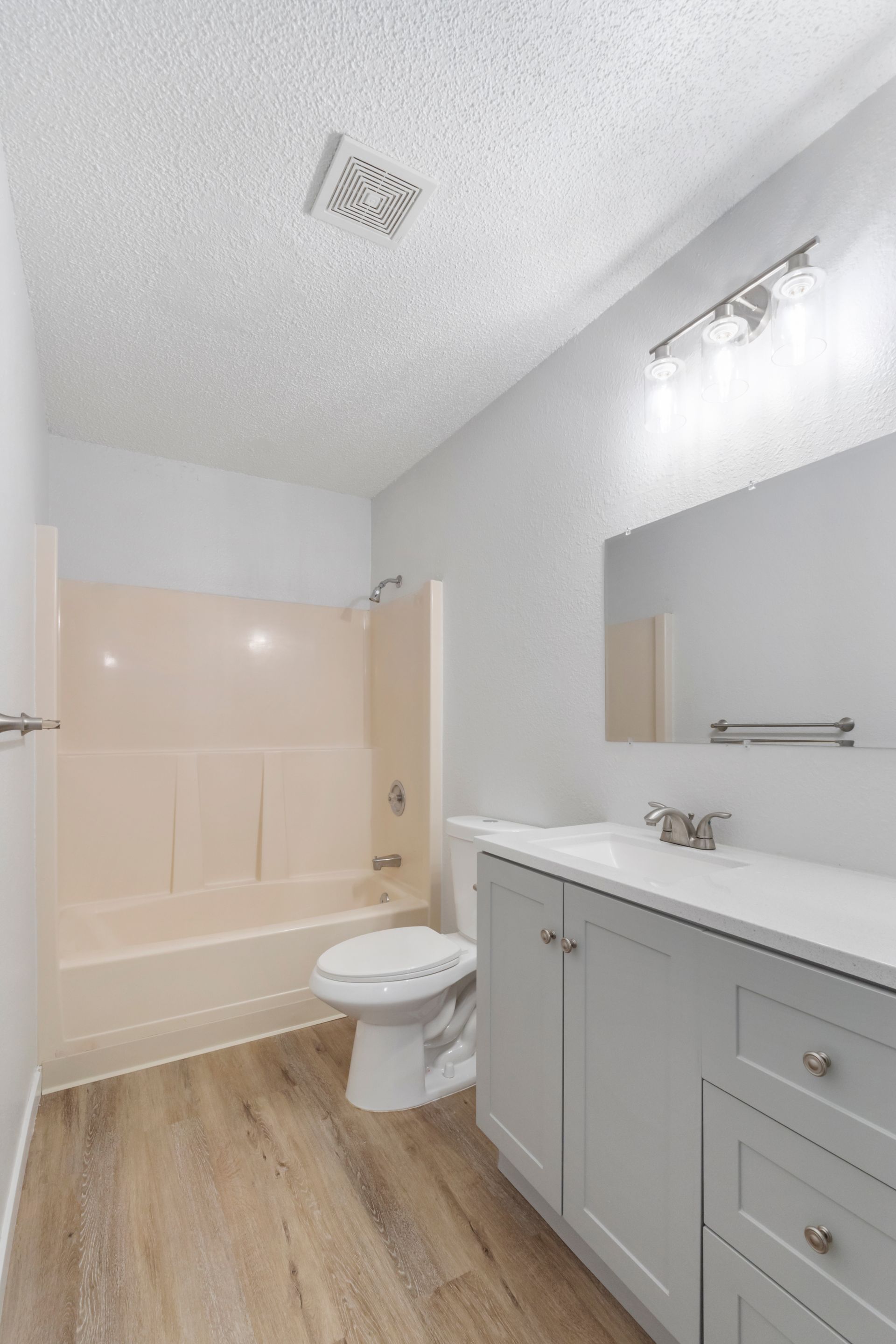 A bathroom with a toilet , sink , and bathtub.