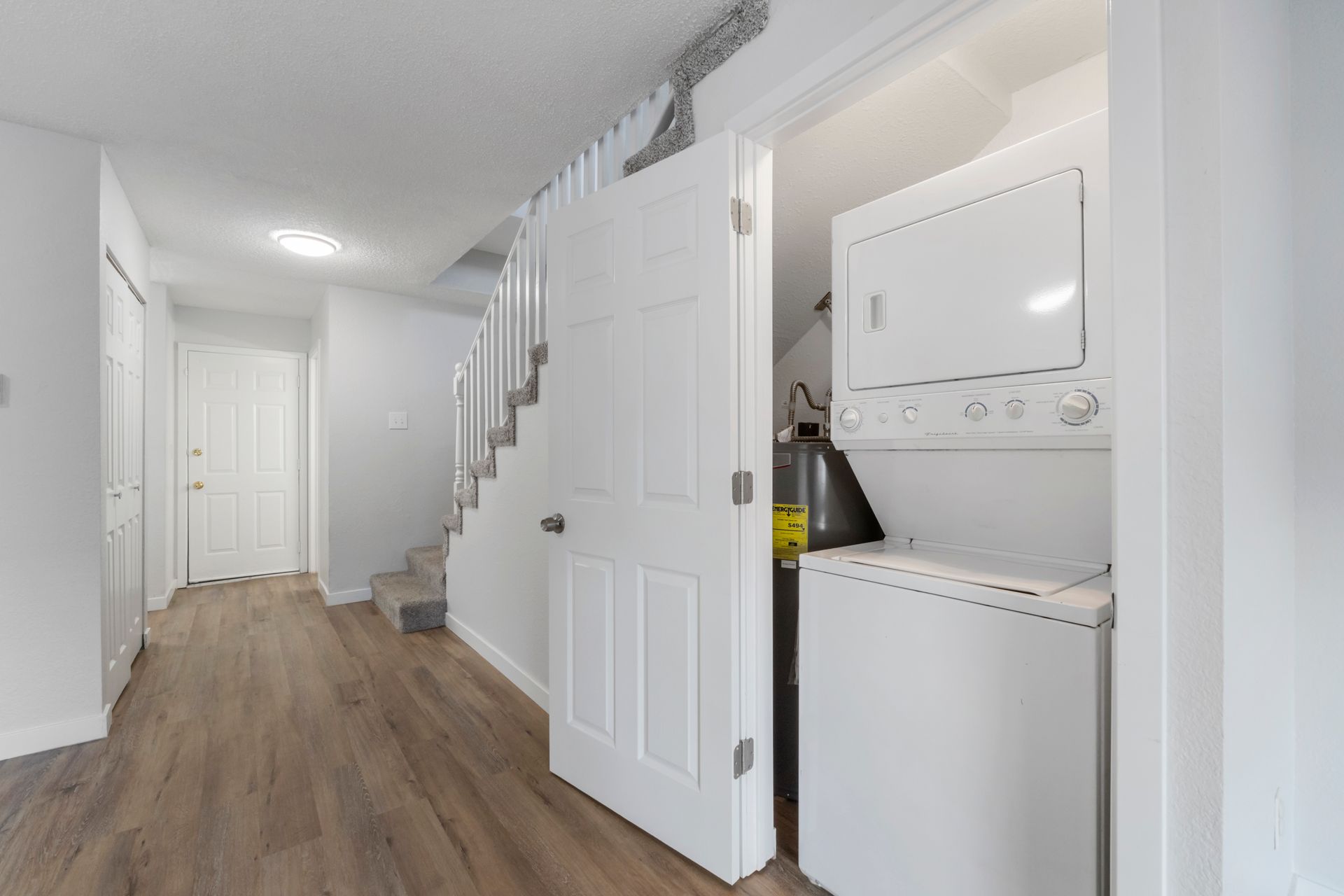 A washer and dryer are stacked on top of each other in a closet.