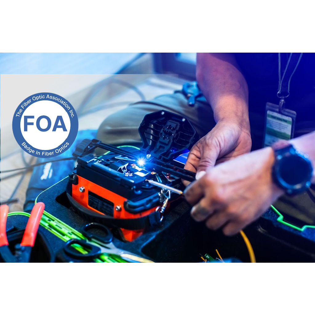 Technician using a fiber optic fusion splicer, FOA logo in the corner.