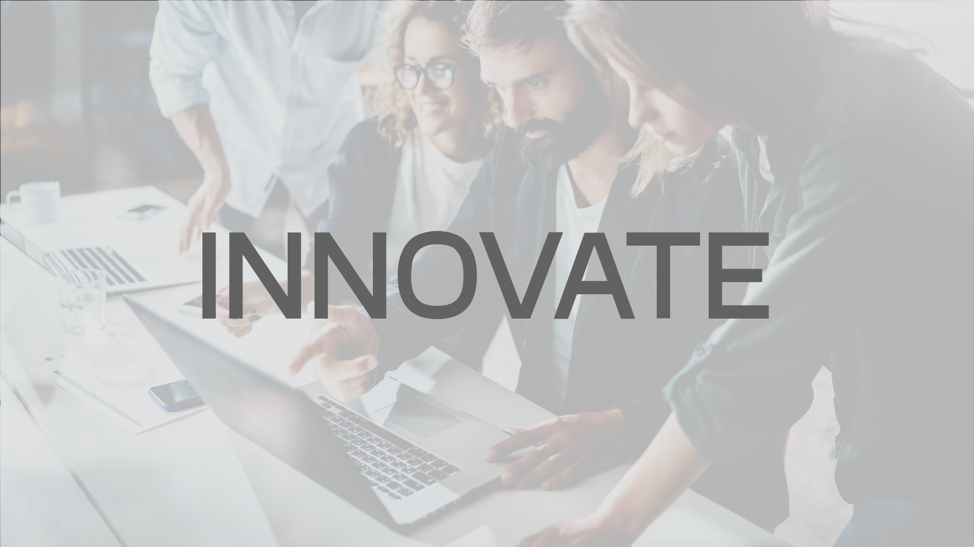 People working together, looking at laptop. Text overlay reads 