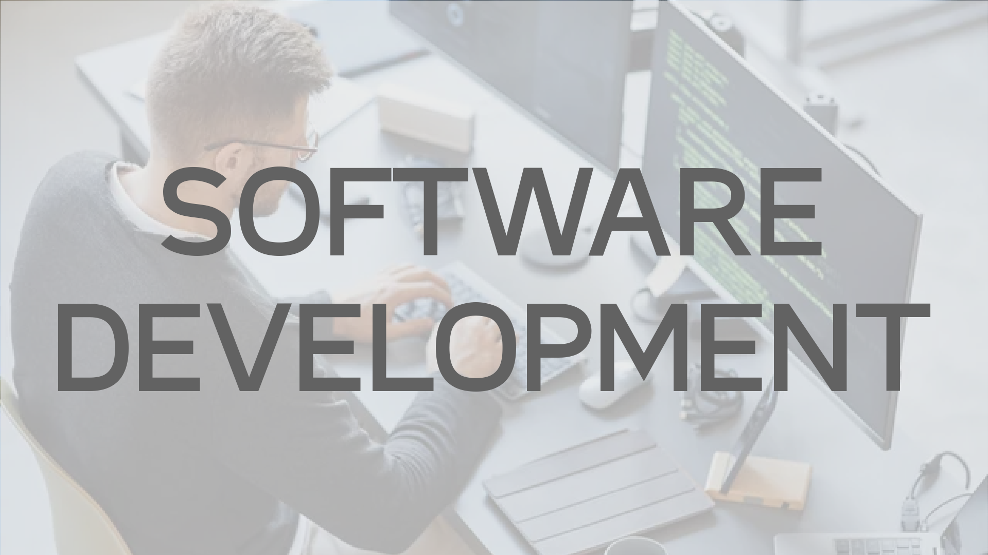 Man at desk working on software; text overlay “SOFTWARE DEVELOPMENT.”