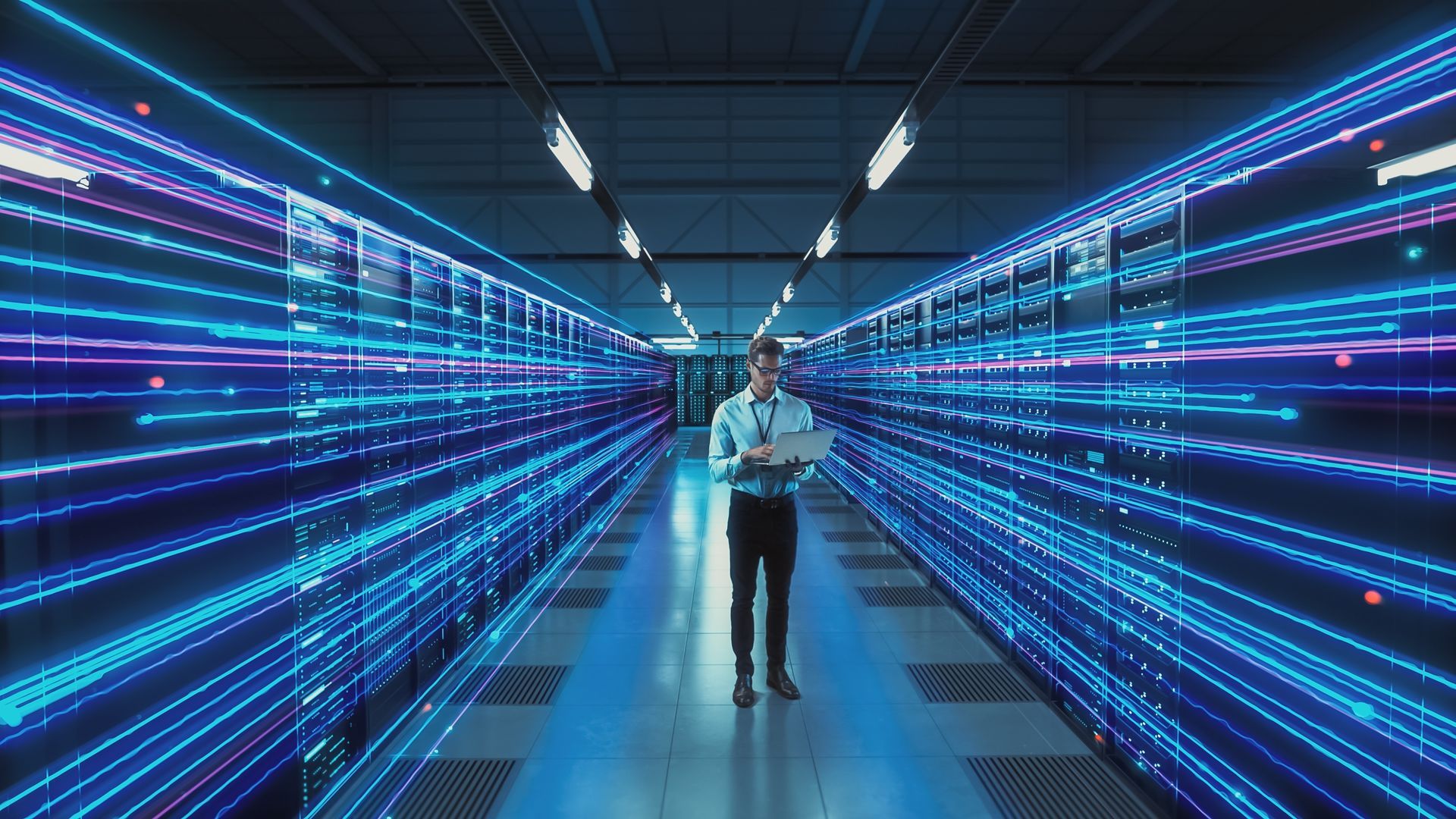 Man in data center, holding tablet, surrounded by glowing blue lines representing data transfer.