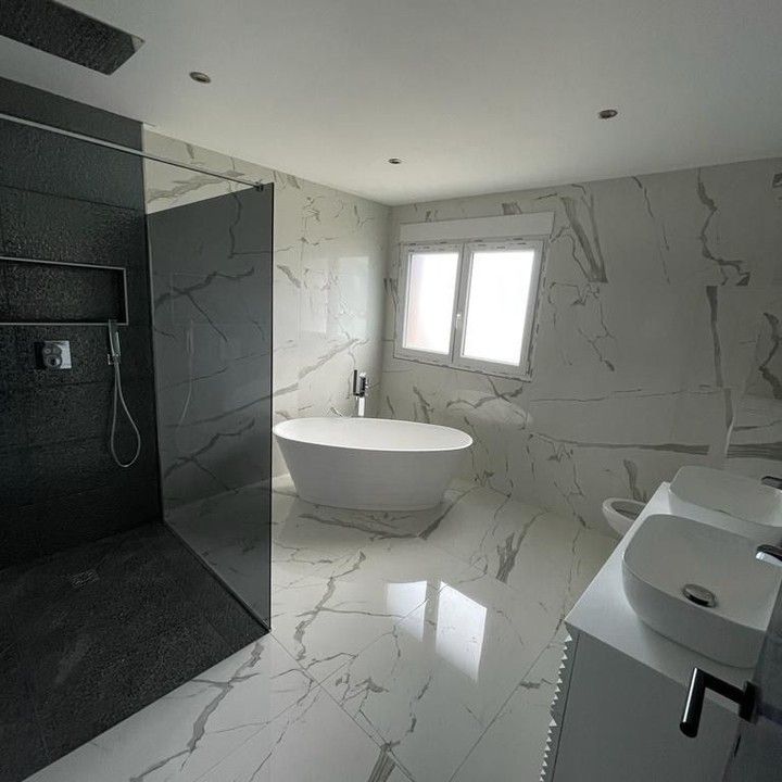 Une salle de bain avec baignoire, lavabo, WC et douche.