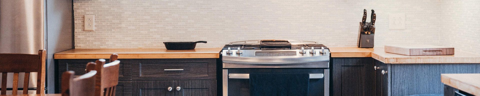 a kitchen with a stove , oven , cabinets and a table .