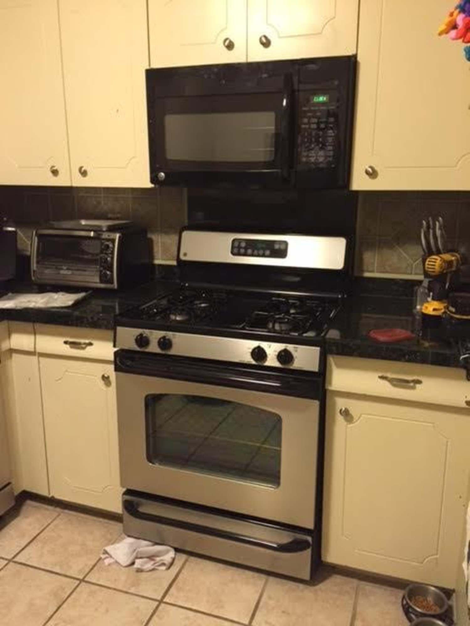 a kitchen with a stove , microwave and toaster oven