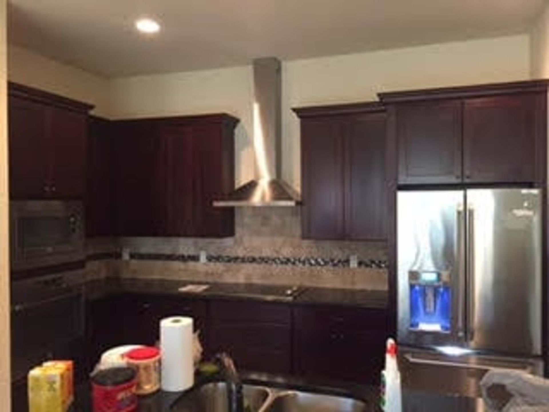 a kitchen with dark wood cabinets and stainless steel appliances